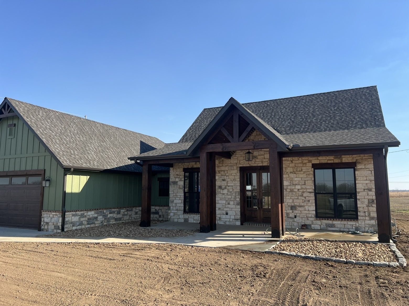 New home with rock beds along the foundation and a graded yard